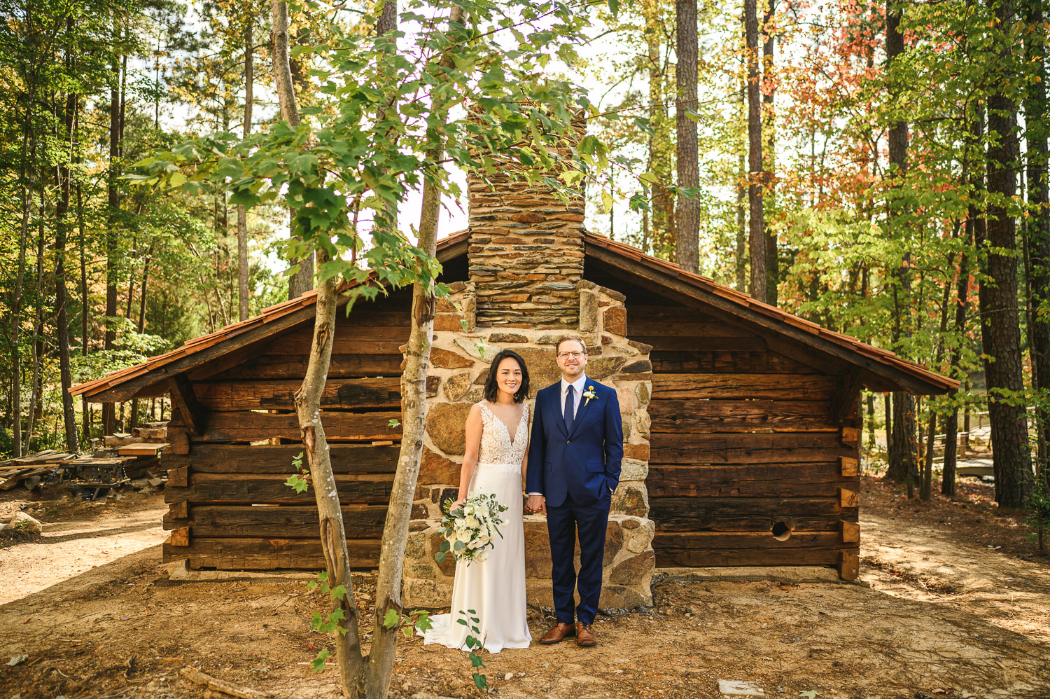 bride and groom in front of a cabin at Union Grove Farm