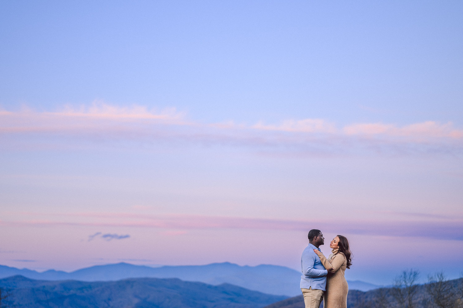 Couple poses with mountains at sunset