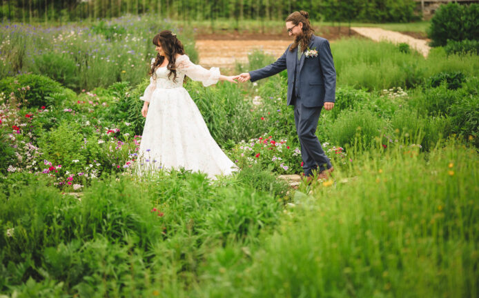 Bride and groom, walking through a garden