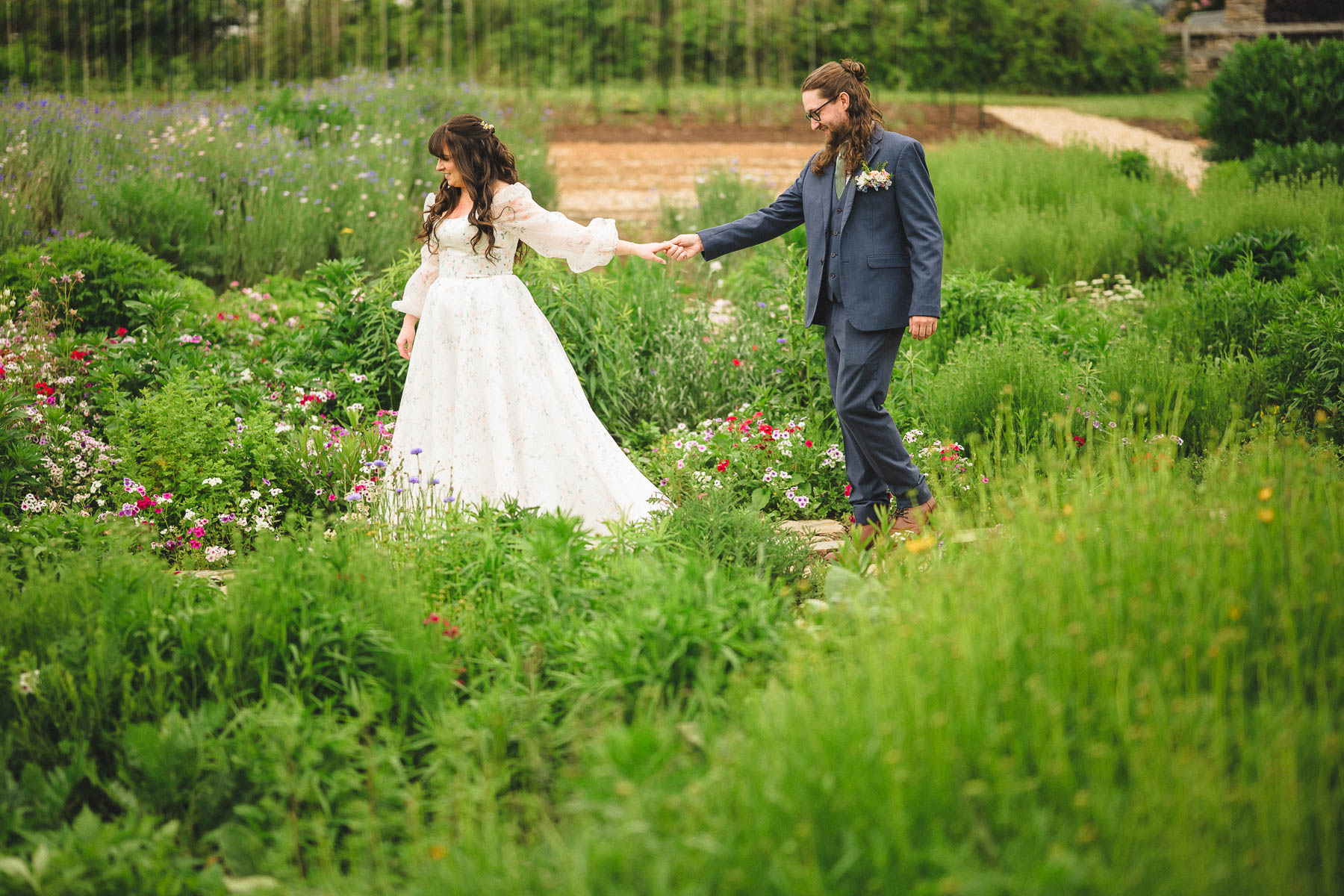 Bride and groom, walking through a garden